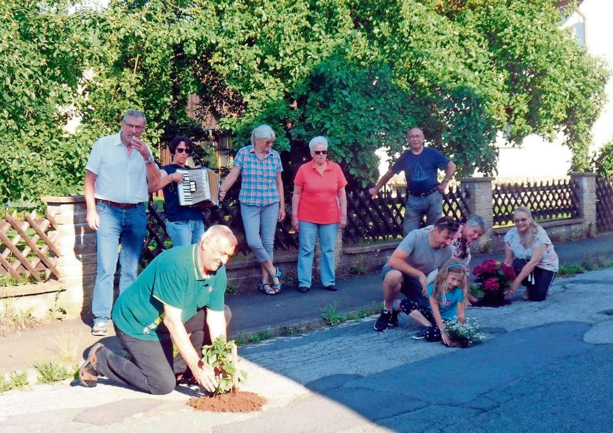 Kartoffeln und Blumen wurden in Schlaglöcher in der Frankenstraße in Neuses gepflanzt. Das Team ist nach getaner Arbeit sehr zufrieden.	Fotos: Heike Schülein