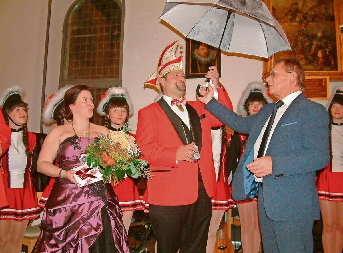 Bürgermeister Wolfgang Beiergrößlein übergibt in seiner Eigenschaft als Schirmherr einen Regenschirm an das scheidende Prinzenpaar Caro I. und Stefan II.