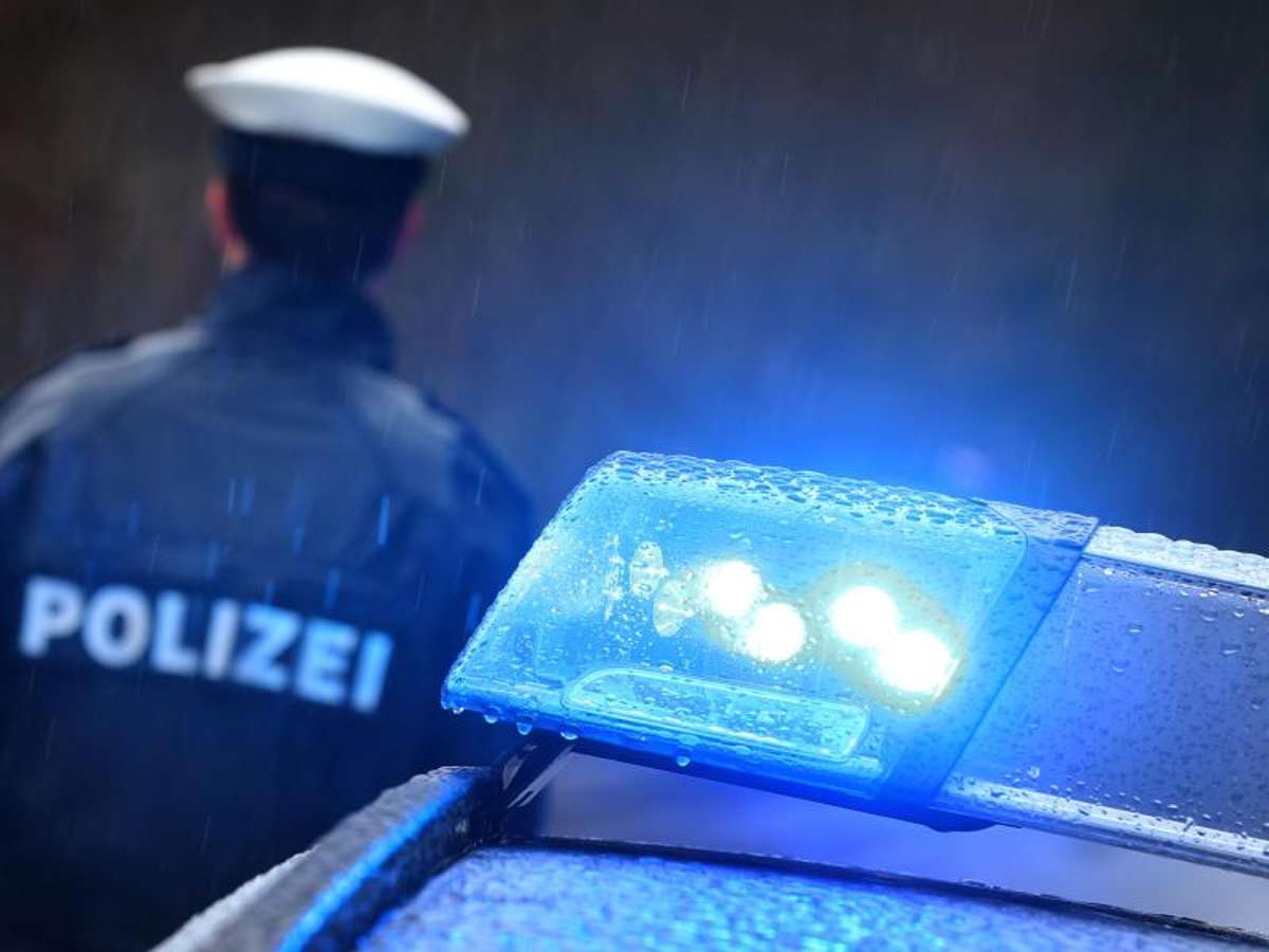 Ein Polizist vor einem Streifenwagen mit Blaulicht. Foto: Karl-Josef Hildenbrand/dpa/Symbolbild