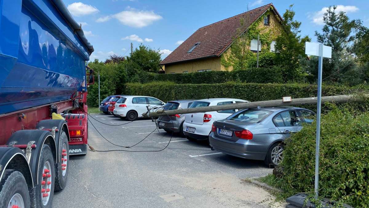 Sattelauflieger beschädigt Telefonleitung: Mast kippt auf geparkte Fahrzeuge.