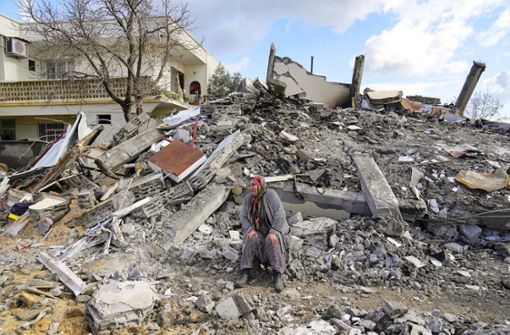 Eine Frau sitzt auf einem Trümmerhaufen. Mehr als 11 000 Menschen sind bei dem Erdbeben ums Leben gekommen. Alles liegt in Schutt und Asche. Foto: picture alliance/dpa/AP/Khalil Hamra
