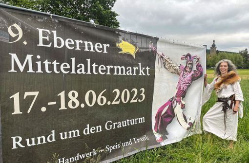 Die Banner sind entrollt, die Werbung kann anlaufen: Karin Fenn (in mittelalterlichem Gewande) freut sich auf die neunte Auflage des Mittelaltermarkts in Ebern. Foto: Tanja Kaufmann