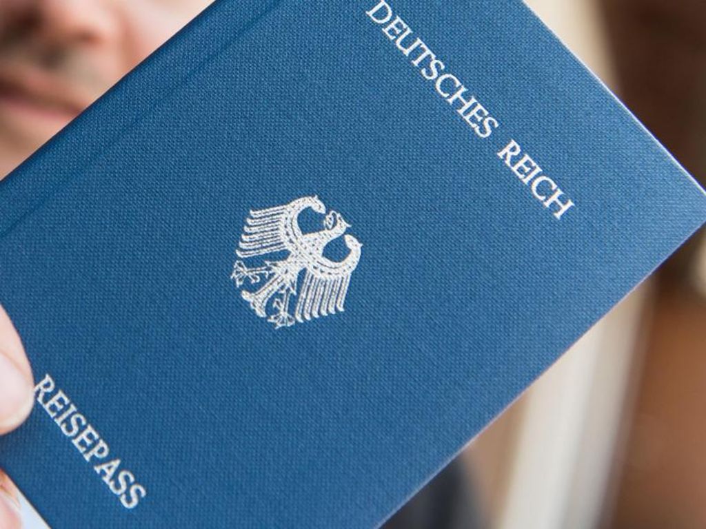 Ein Mann hält ein Heft mit dem Aufdruck «Deutsches Reich Reisepass» in der Hand. Foto: Patrick Seeger/Archiv Quelle: Unbekannt