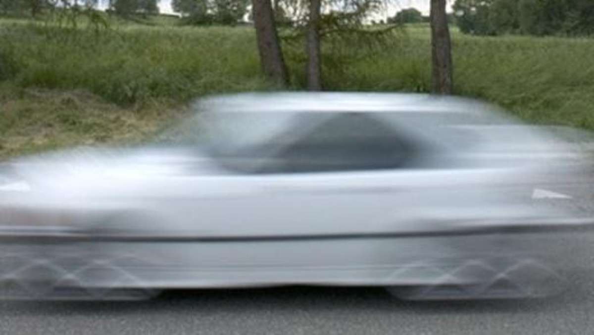 Ein Auto fährt mit hoher Geschwindigkeit auf einer Straße. Symbolbild.